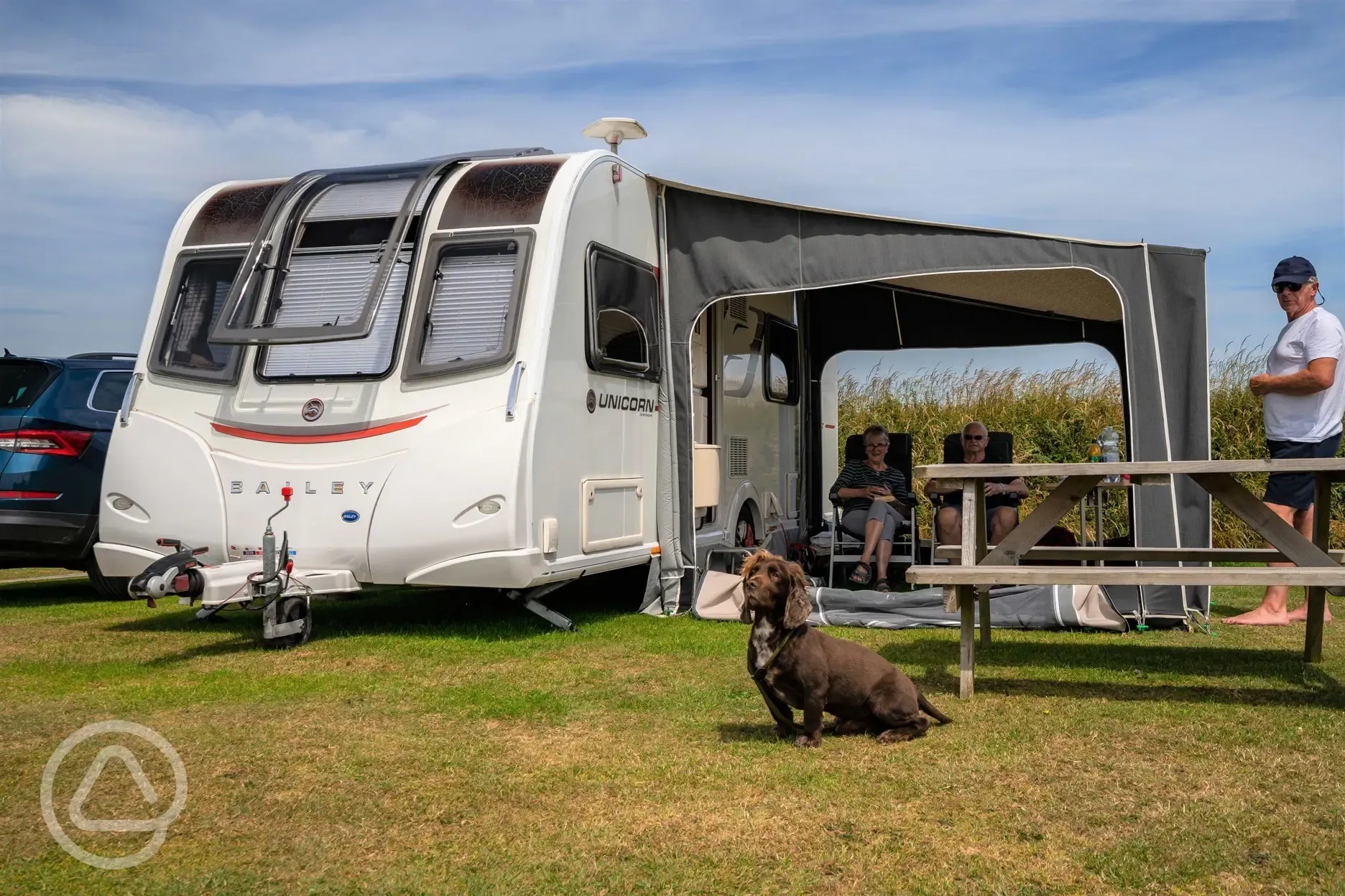 Caravan with an awning on electric grass pitches