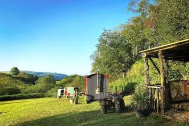 Shepherd's huts beside the communal area at Wenallt Wild Camp