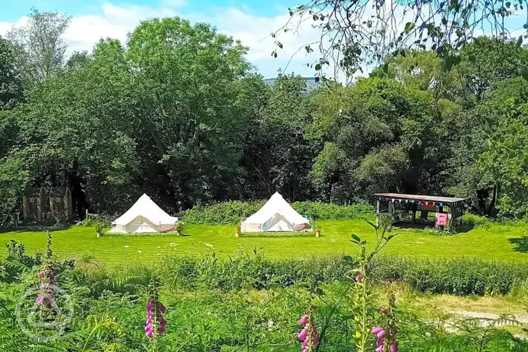 View of the two bell tents on raised decking beside the communal area