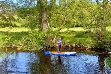 Paddle boarding on the River Rule, running alongside Bonnie Park