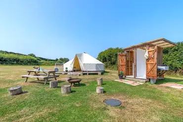 Bell tent exterior and outdoor furniture at Beachside Glamping Dale