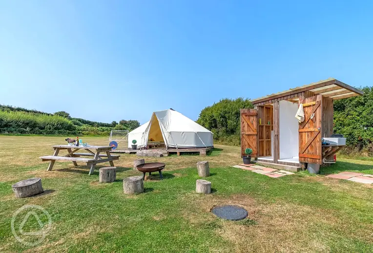 Bell tent exterior and outdoor furniture at Beachside Glamping Dale