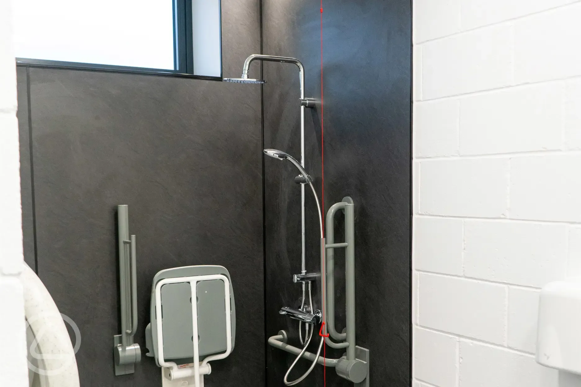 Accessible shower room with a seat and grab rails