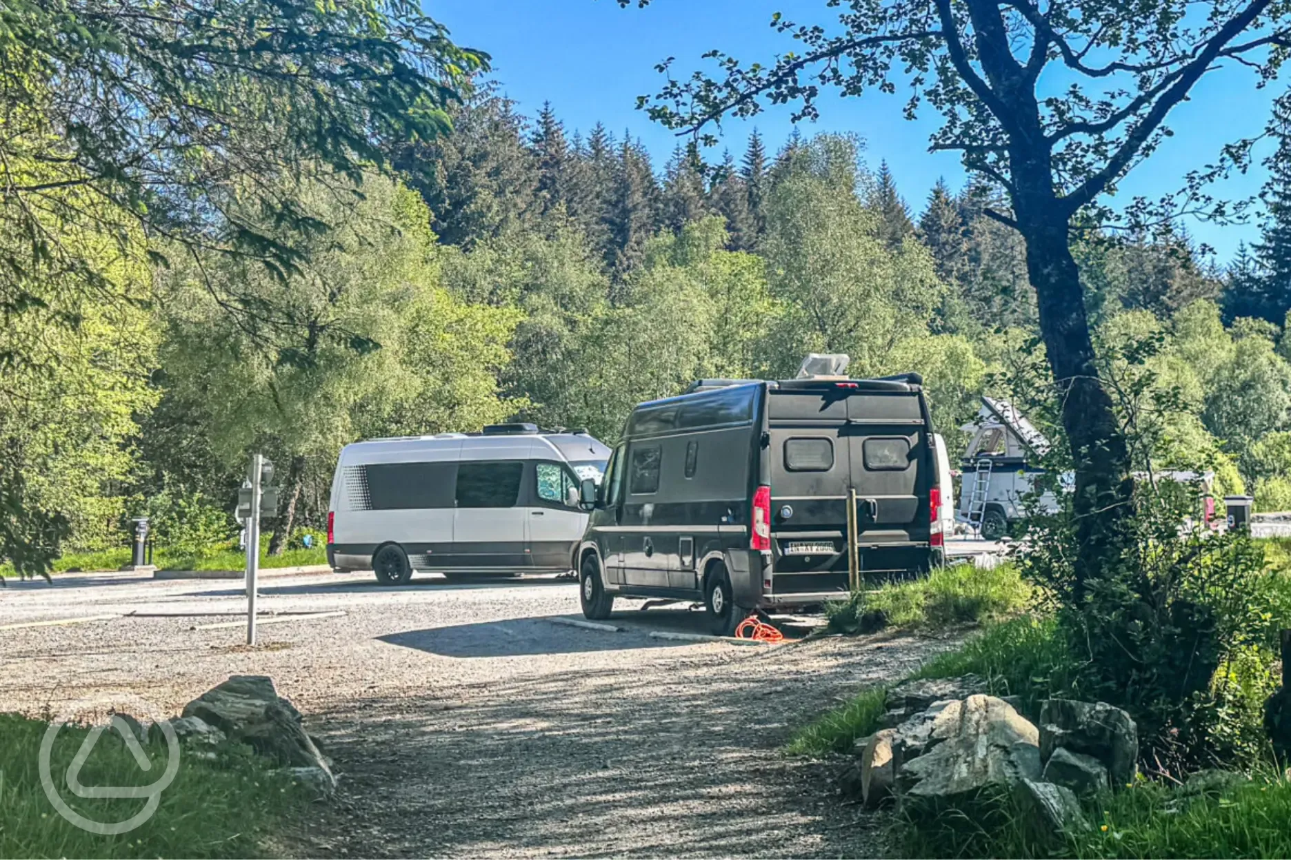 Electric hardstanding pitches with woodland surrounding the park