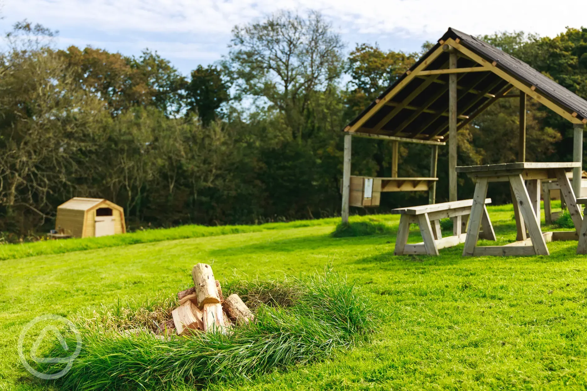 Ensuite grass pitches with fire pits and undercover dining areas