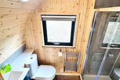 Ensuite with a flushing toilet, shower, hand basin and a heated towel rail