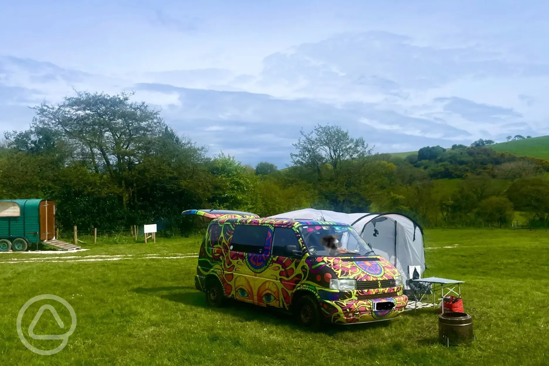 Camper van pitched up on a non electric grass pitch.