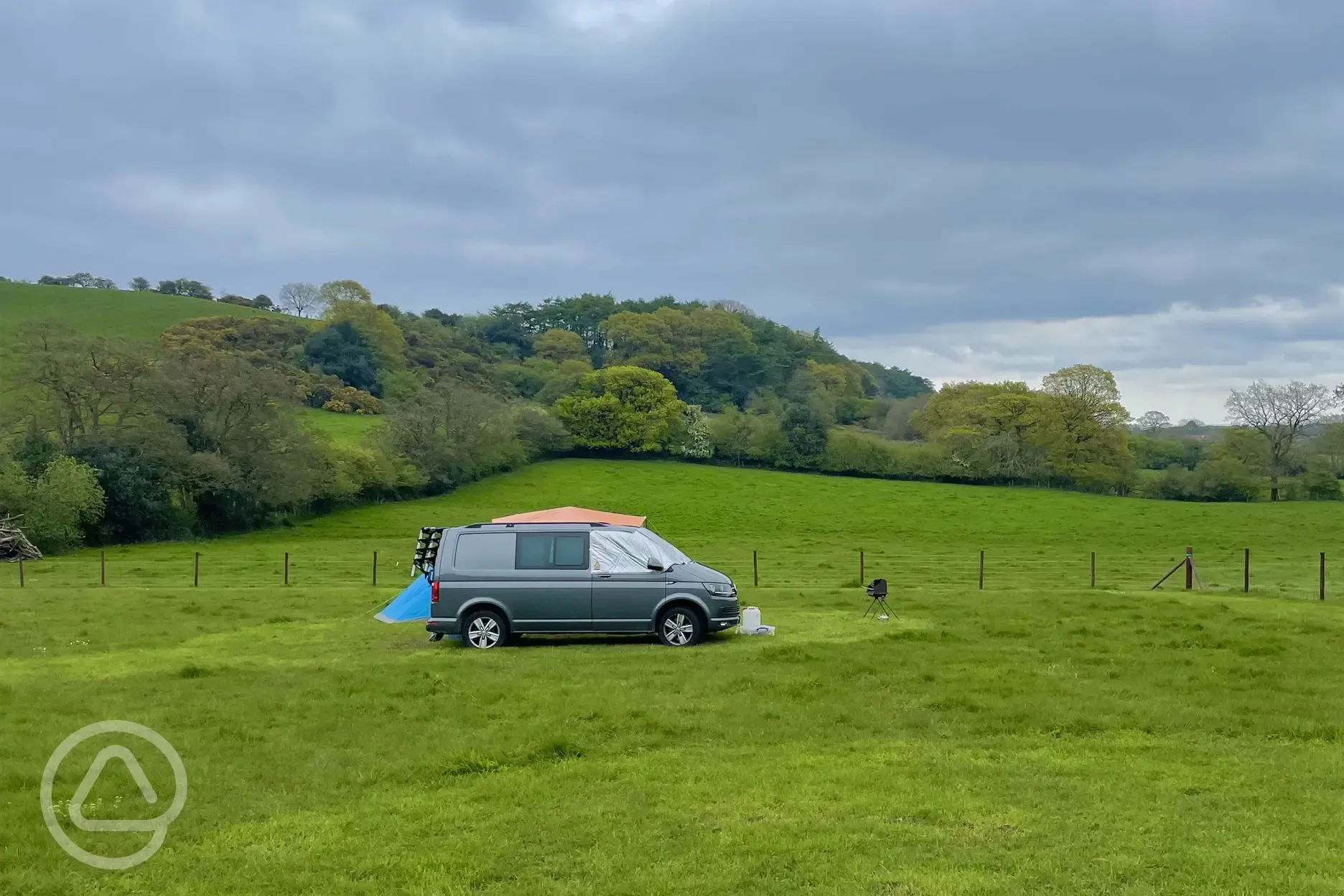 Camper van pitched up on a non electric grass pitch.