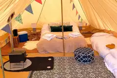Part furnished bell tents with a double bed and optional airbeds