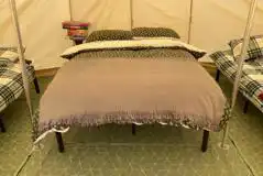 Bell tent interior with double bed and two single beds