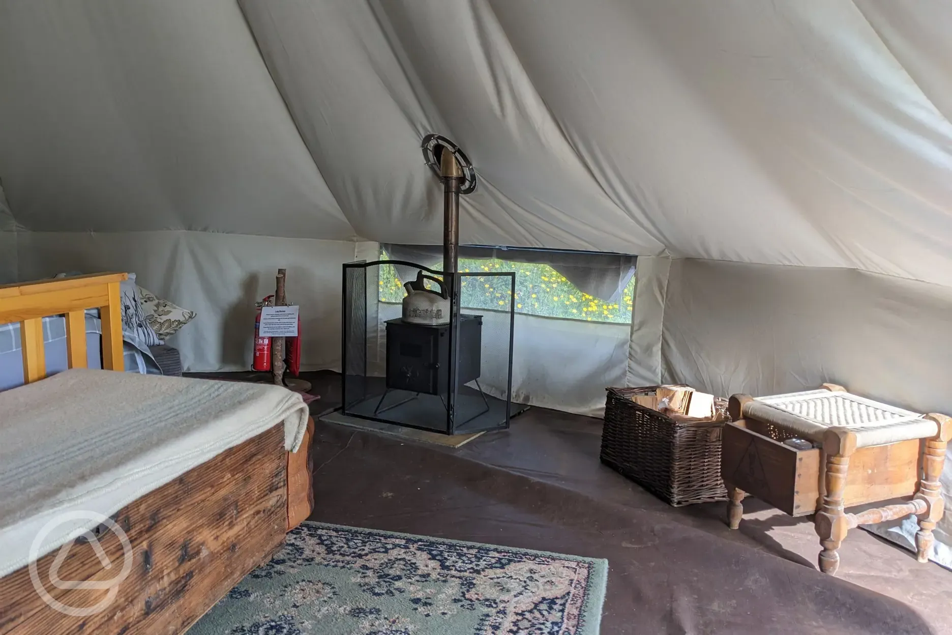 Inside bell tent with log burner