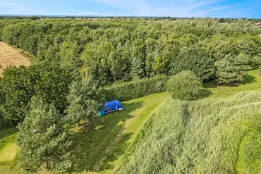 Aerial of the grass tent pitches with shade from trees