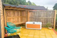 Owl glamping pod outside area with a hot tub