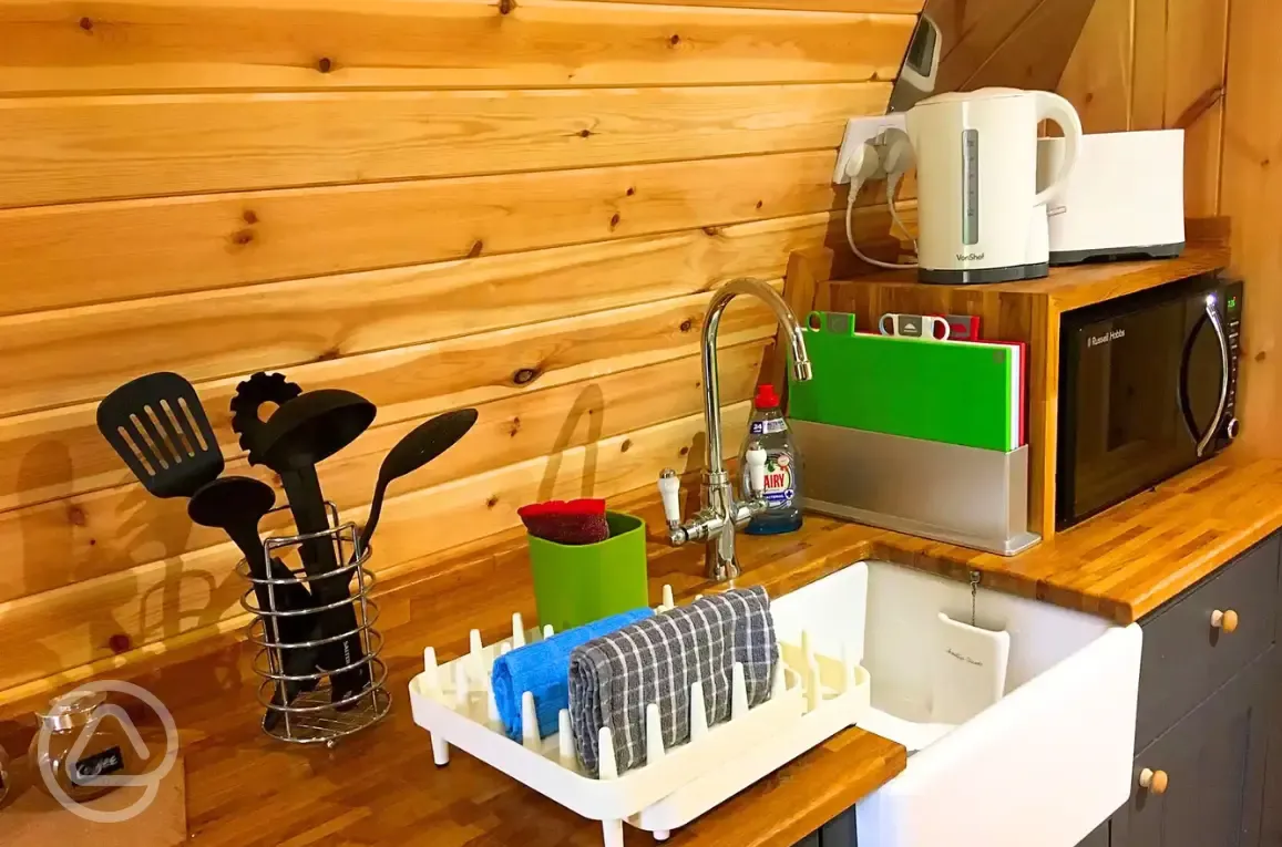 Pod kitchenette with sink, microwave, utensils, toaster and kettle