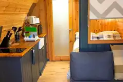 Pod interior with lounge area, bed, kitchenette and door to the ensuite bathroom Pod interior with lounge area, bed, kitchenette and door to the ensuite bathroom