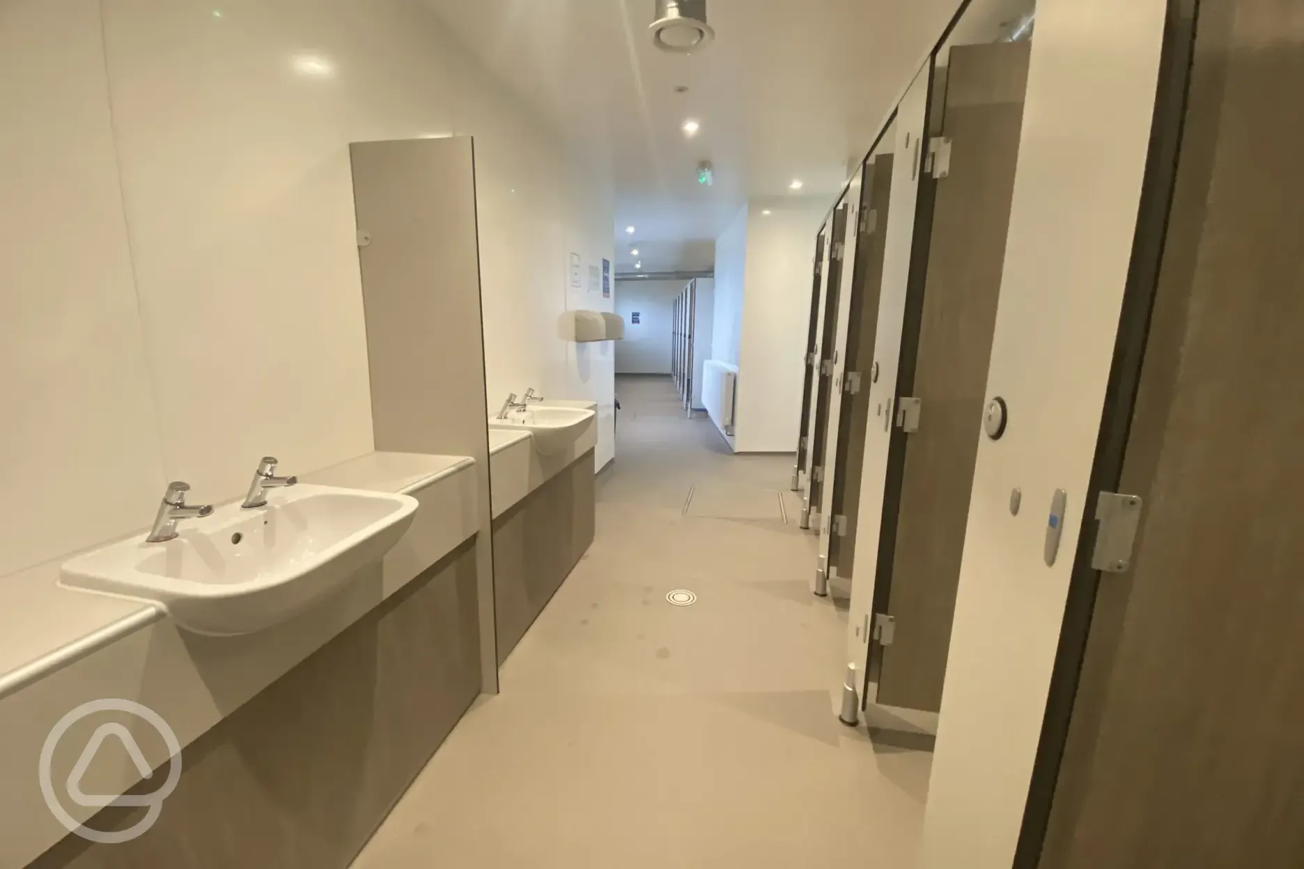 Toilets at Lynmouth Holiday Retreat with sinks and private cubicles