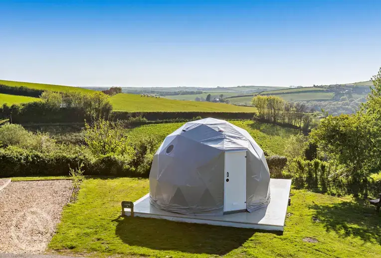 geodome exterior with far reaching countryside views and sheep
