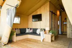 Safari tent living area with a sofa and TV