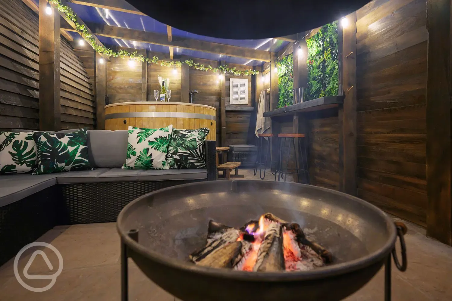 Fire pit and hot tub in the private patio area of the Greenriggs pod