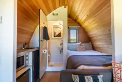 Glamping pod interior with a double bed, kitchen and ensuite Glamping pod interior with a double bed, kitchen and ensuite