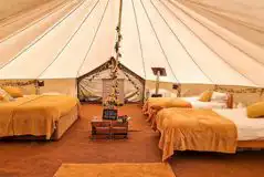 Sunflower bell tent interior with a double and four single beds (linen provided) Sunflower bell tent interior with a double and four single beds (linen provided)