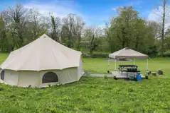 Furnished bell tents with private sheltered seating and a fire pit Furnished bell tents with private sheltered seating and a fire pit