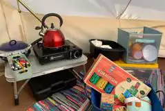 Bell tent kitchen area and games 