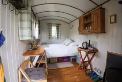 Shepherd's hut interior with a double bed and bedding Shepherd's hut interior with a double bed and bedding