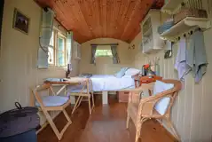 Shepherd's hut interior with a double bed and bedding Shepherd's hut interior with a double bed and bedding