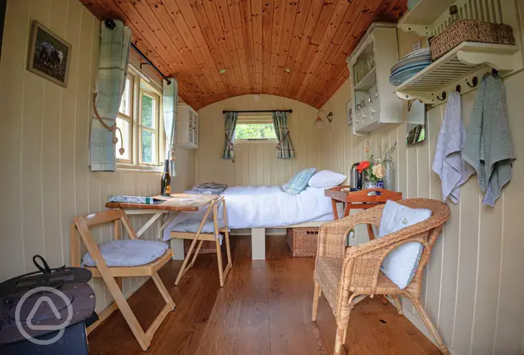 Shepherd's hut interior with a double bed and bedding