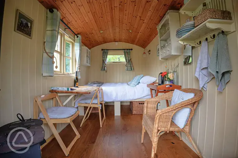 Shepherd's hut interior with a double bed and bedding