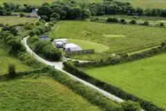 Aerial view towards Buzzard's Landing pitch with a shepherd's hut bathroom