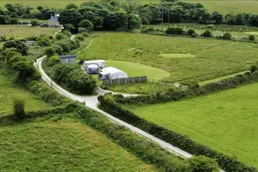 Aerial view towards Buzzard's Landing pitch with a shepherd's hut bathroom