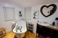 Buzzard's Landing bathroom with a shower, toilet and roll top bath