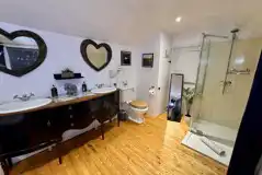 Buzzard's Landing bathroom with a shower, toilet and roll top bath