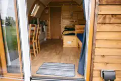 View into the ensuite glamping pod with seating, a double bed, and kitchenette