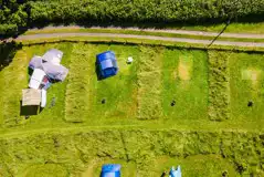 Aerial of pitches with firepit and space between each pitch Aerial of pitches with firepit and space between each pitch