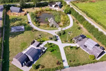 Aerial of Ravensdale Glamping Retreats with pods set around a wildlife pond