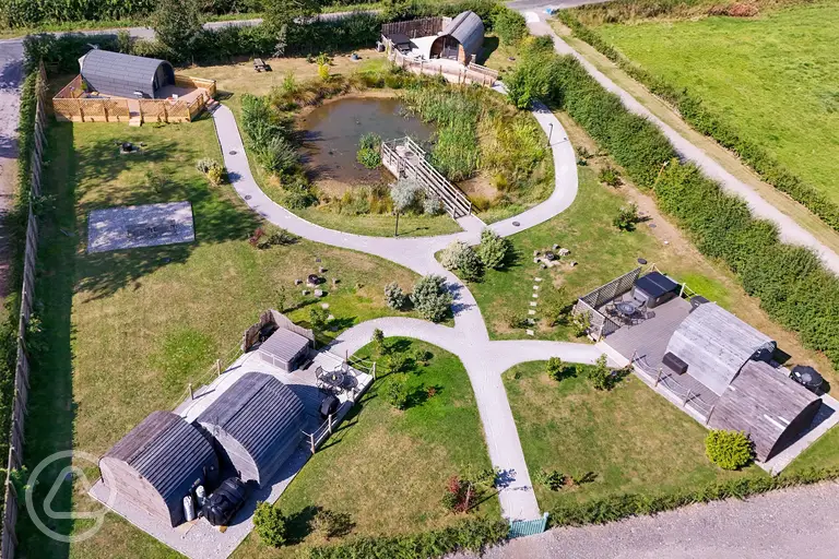 Aerial of Ravensdale Glamping Retreats with pods set around a wildlife pond