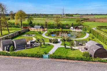 Four glamping pods set around a wildlife pond