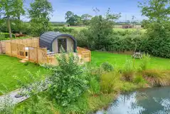 Paddywack pod with a large decking area with a hot tub and privacy fencing