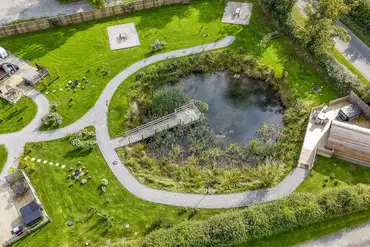 Aerial of Ravensdale Glamping Retreats with pods set around a wildlife pond