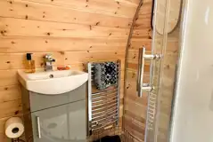 Chaplin's Club pod ensuite with a toilet, shower, hand basin, towels and robes