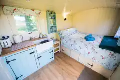Delilah shepherd's hut interior with kitchenette and double bed