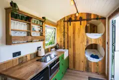 Rusty shepherd's hut interior with kitchenette and double pod beds