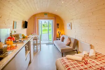 Cuddfan ensuite pod with a sofa bed, kitchenette, dining area, and French doors