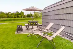 Glamping pods outside patio with a picnic bench, sun loungers, and fire pit Glamping pods outside patio with a picnic bench, sun loungers, and fire pit