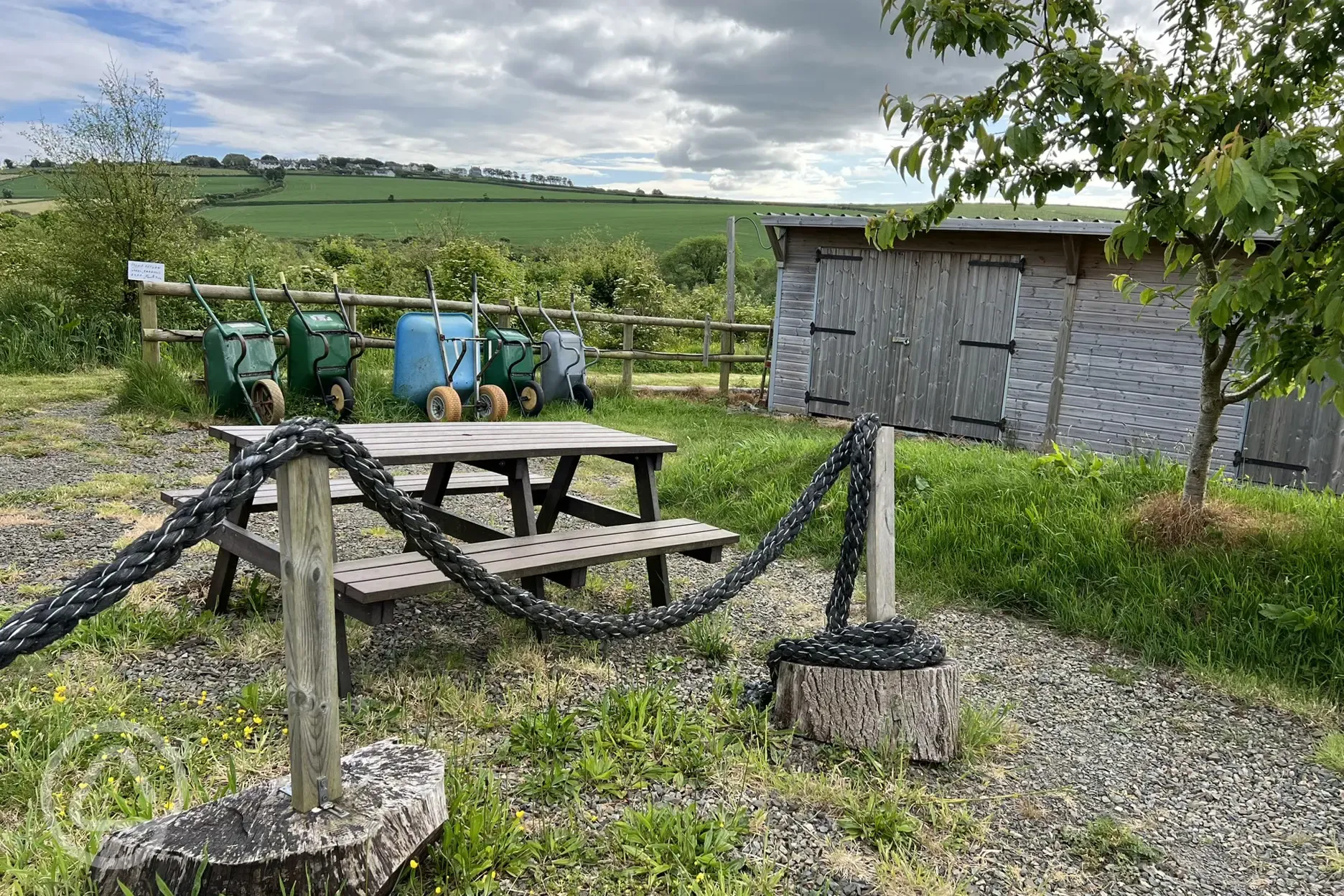 Wood store and wheel barrows