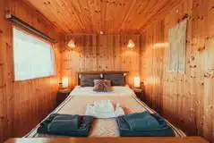Caban Marta interior with a double bed with bedding and towels Caban Marta interior with a double bed with bedding and towels