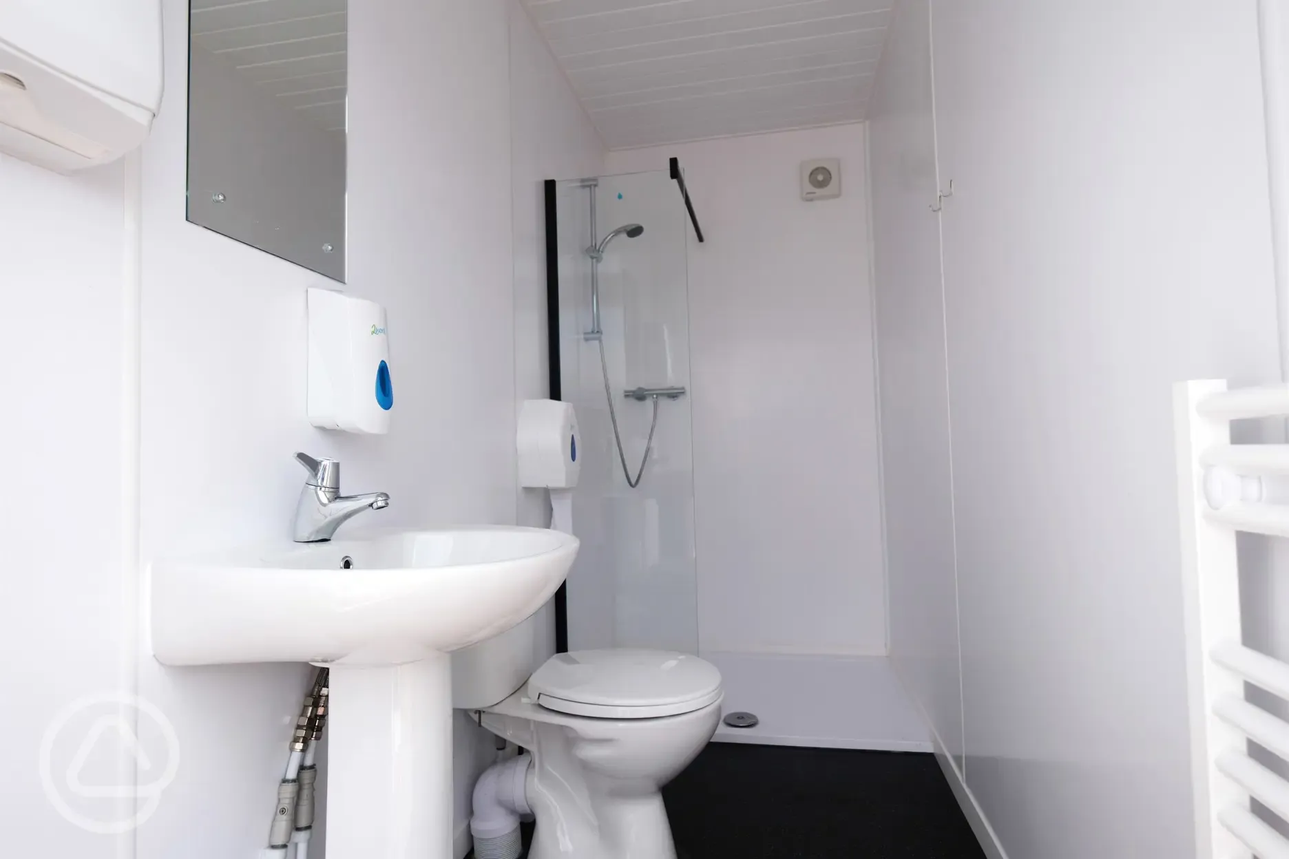 Bathroom interior with toilet, shower, heated towel rail, sink and mirror